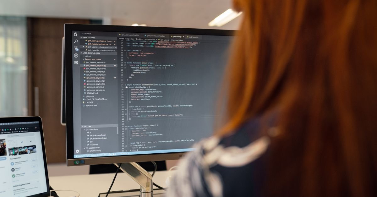 A software engineer writing code at a computer in a modern office